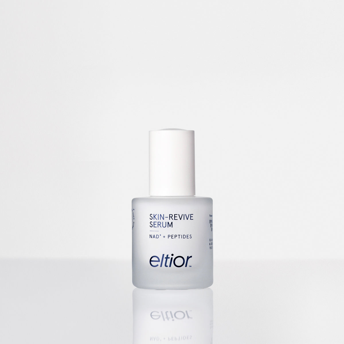 A bottle of Eltior Skin-Revive Serum with a white cap and frosted glass bottle, set against a clean white background with a soft reflection below.
